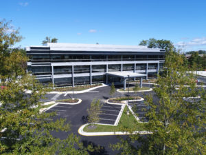 The front facade of the building surrounded by trees.