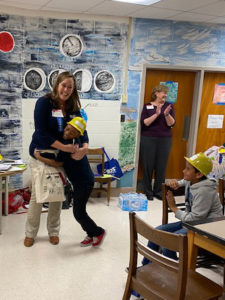 Cassie hugs the second place winner while the teacher and other students applaud.
